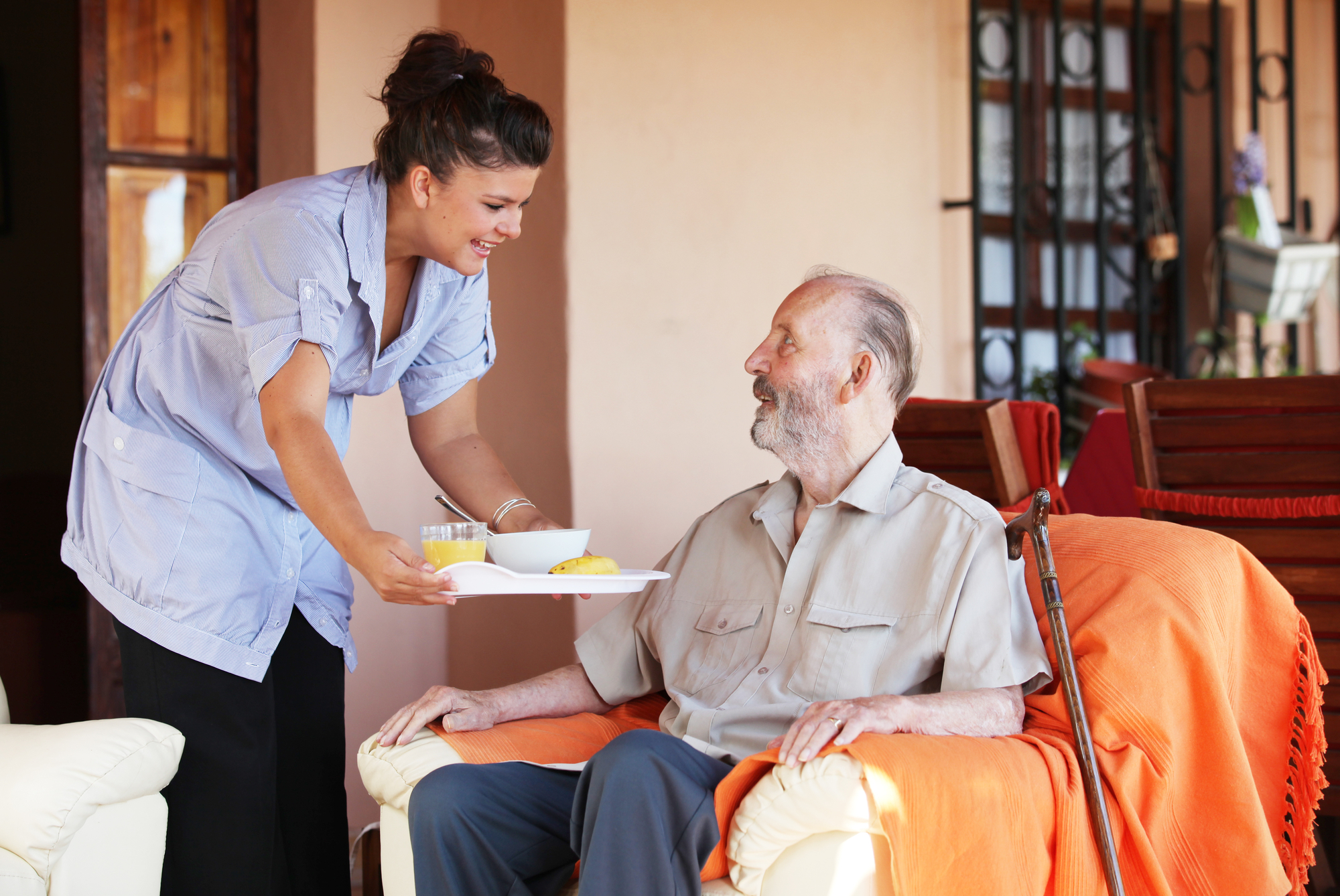 Nurse Serving Food to an Elderly Male