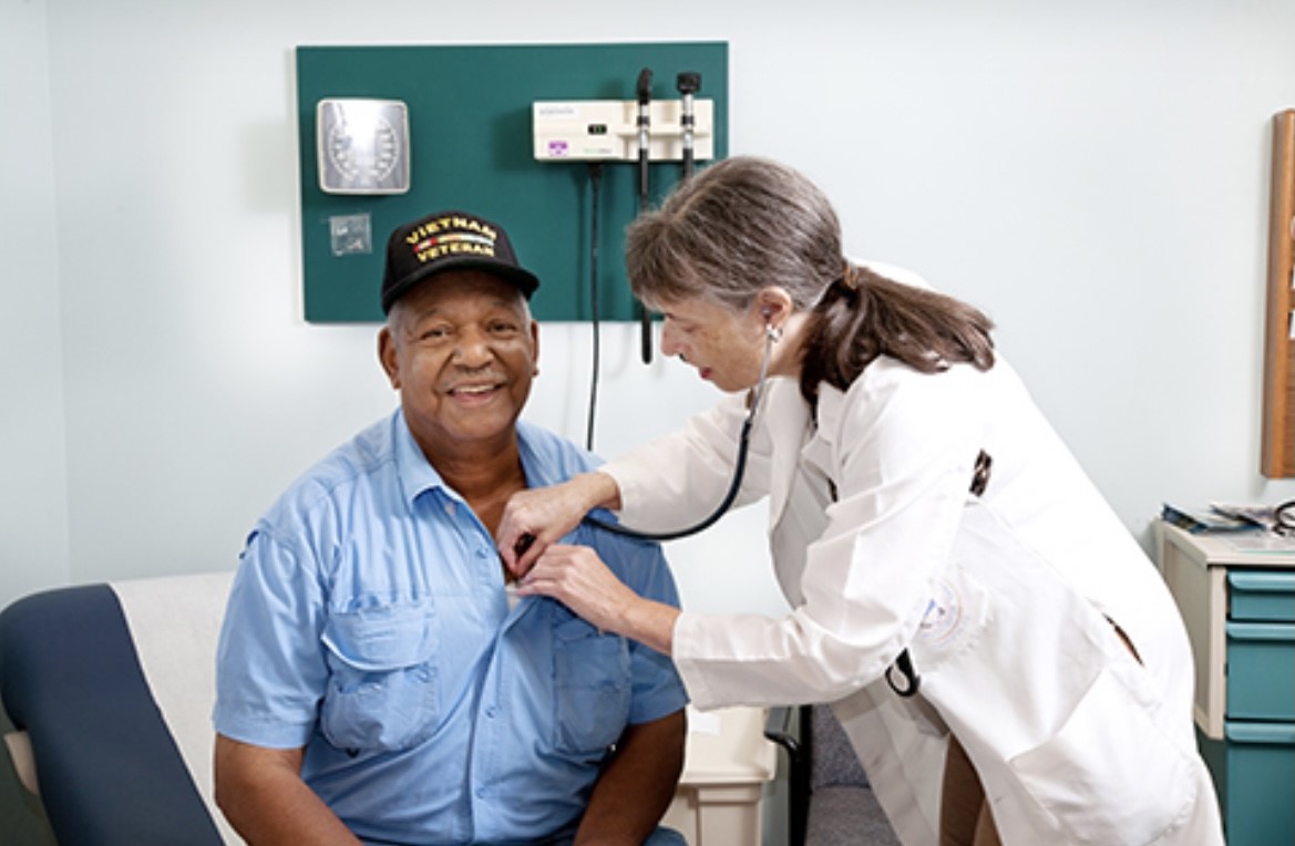 Doctor Checking Heartbeat of a Veteran in Blue Uniform